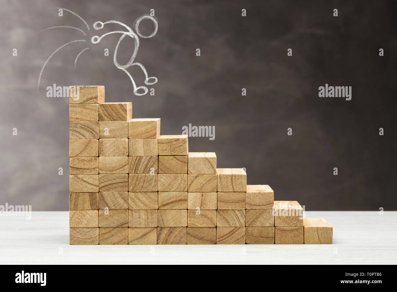 Concetto di diminuire. Grafico con gradini in legno su uno sfondo grigio, con forma umana cade. Foto Stock