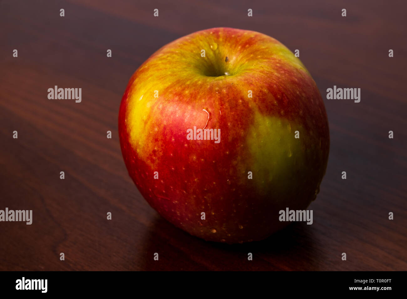 Sana apple organico isolato su un legno scuro dello sfondo Foto Stock