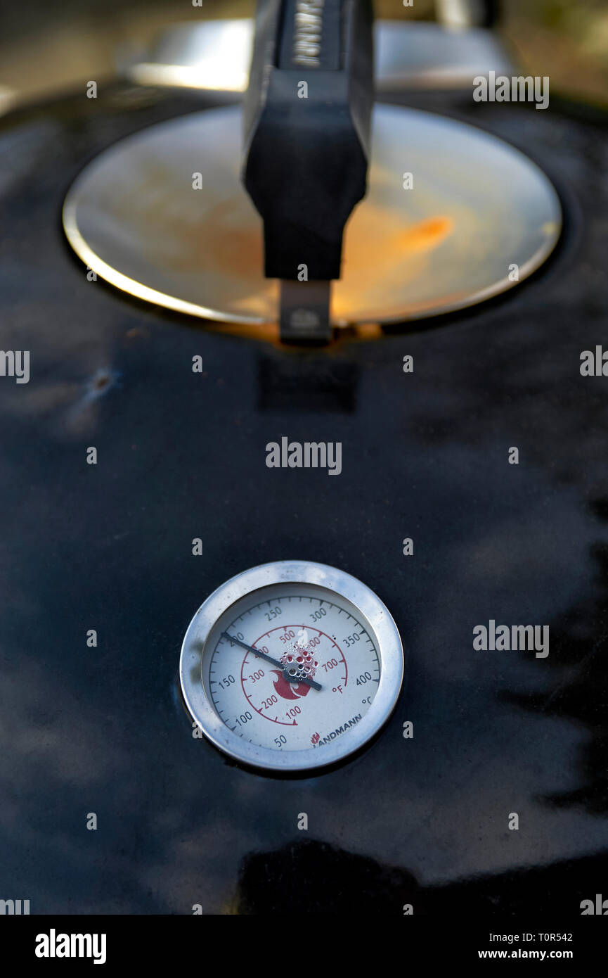 Temperaturanzeige eines Kugelgrills im Deckel mit Handgriff. Das zeigt Termomether 200 C° Foto Stock