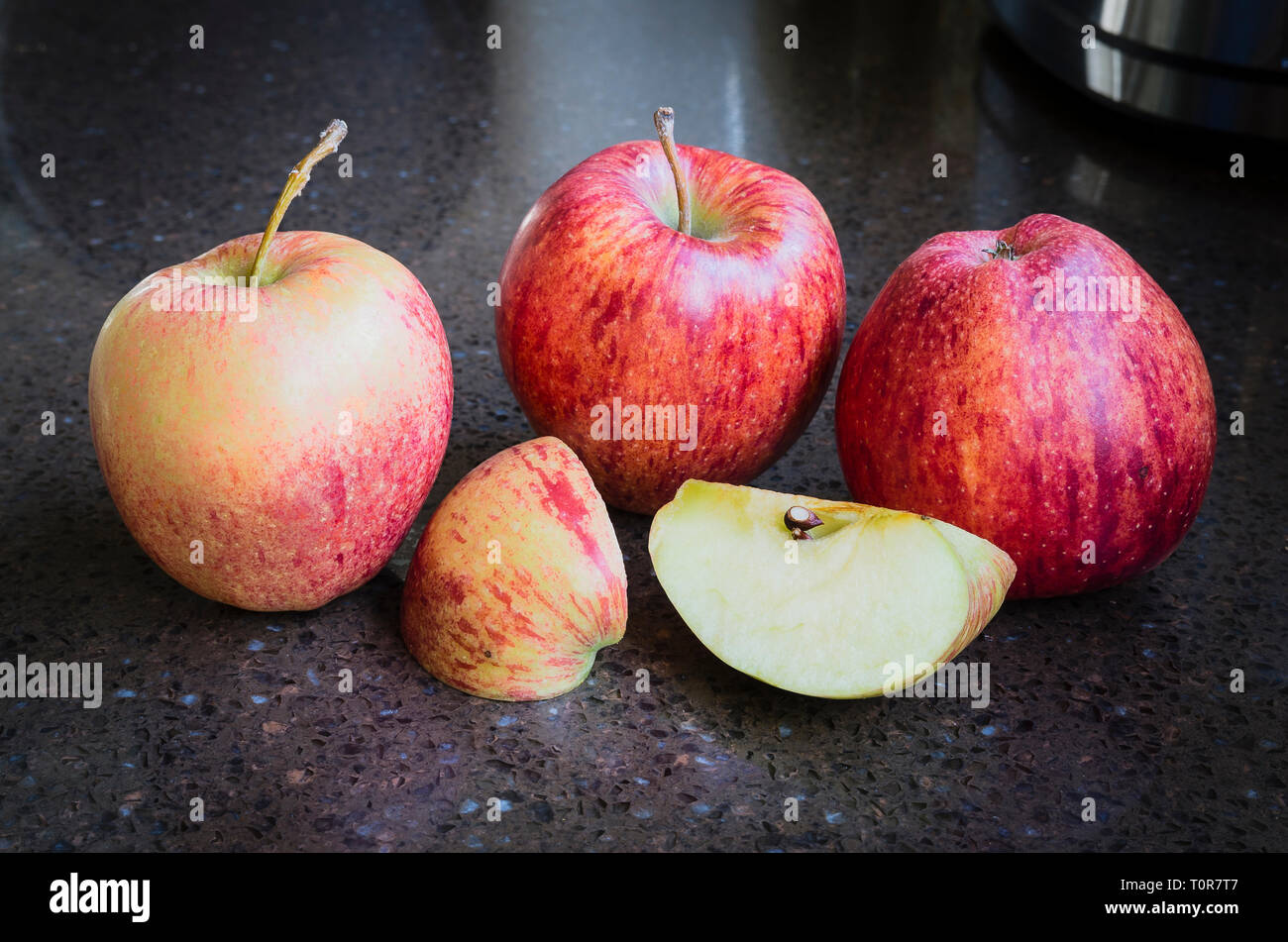Un gruppo di quattro British-cresciute mature Cameo rosso di mangiare le mele pronto per mangiare Foto Stock