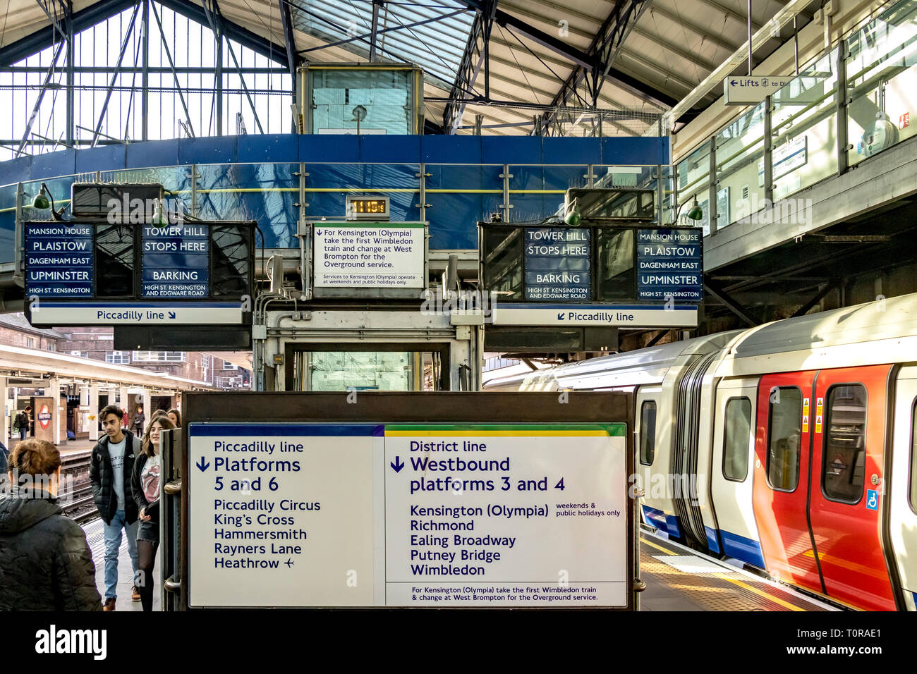 Le tavole indicatrici del treno blu d'epoca annunciano informazioni sui treni ai passeggeri alla stazione della metropolitana di Earls Court , Londra, Regno Unito Foto Stock