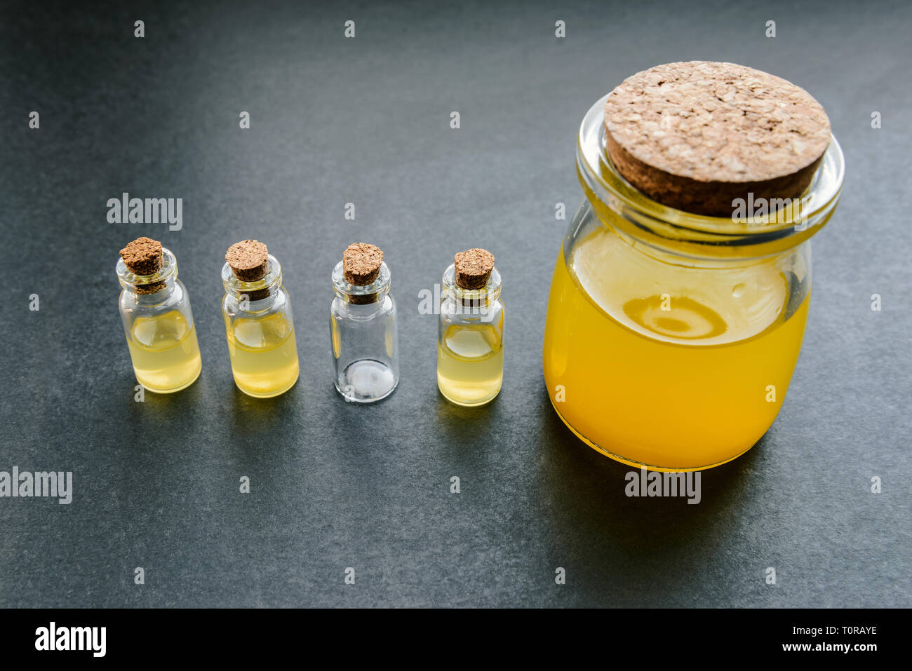 Liquido arancione in un vasetto di vetro. Messa a fuoco selettiva e profondità di campo. Foto Stock