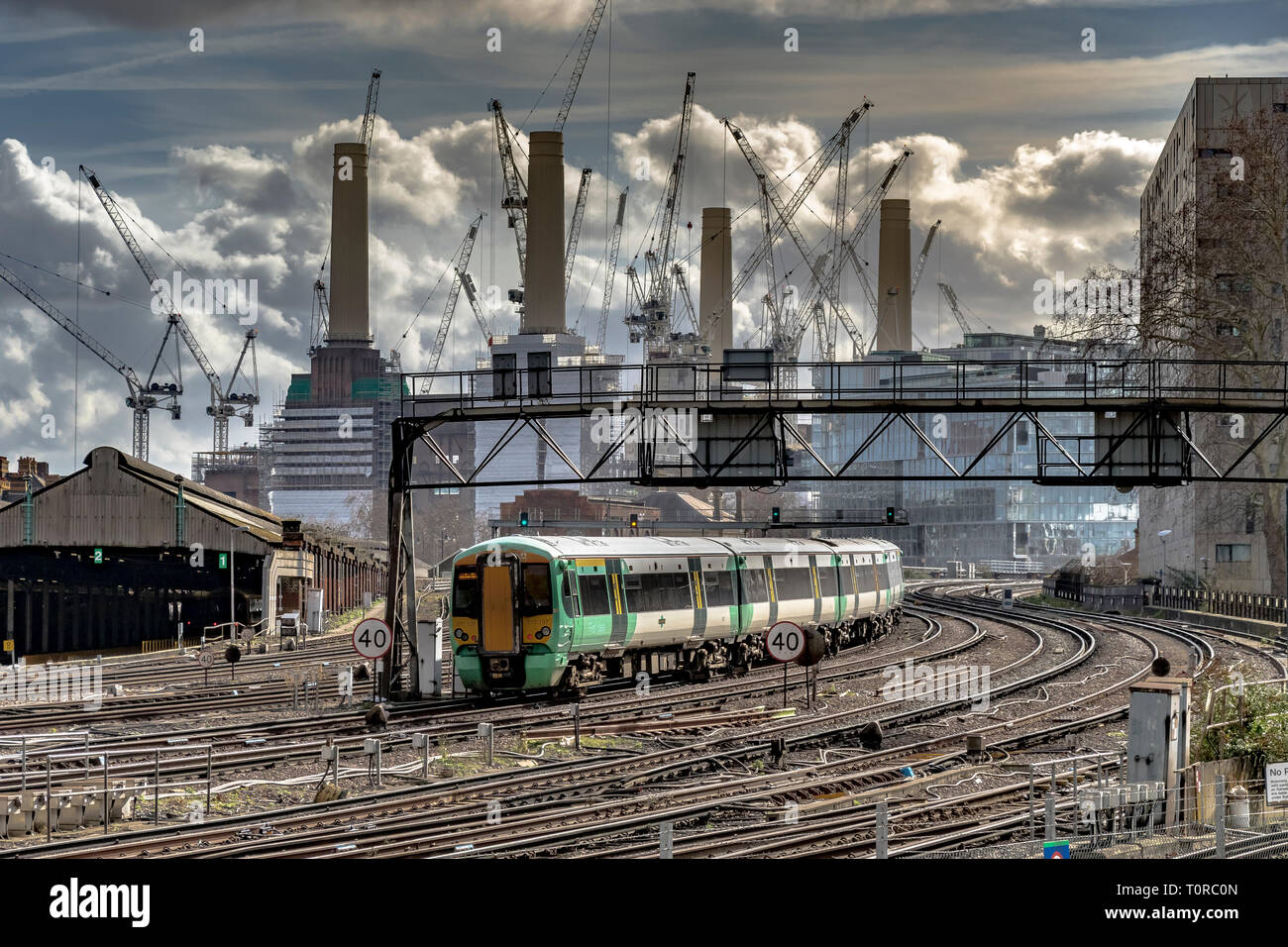 Un treno della Southern Rail che si avvicina a Ebury Bridge sull'approccio finale alla Victoria Station, con la Battersea Power Station in lontananza, Londra, Regno Unito Foto Stock