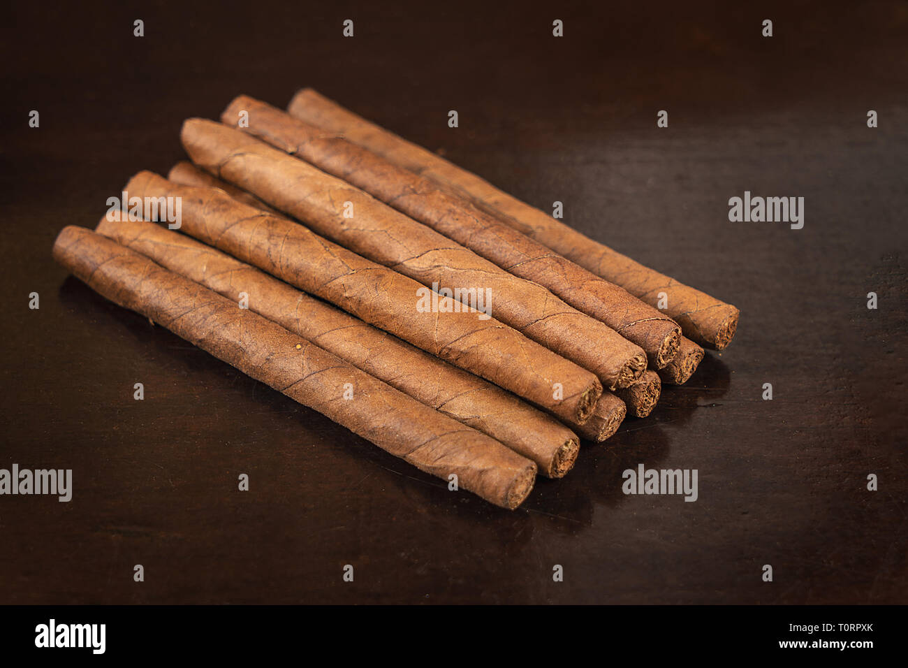 Un gruppo di nove piccoli sigari su un tavolo Foto Stock