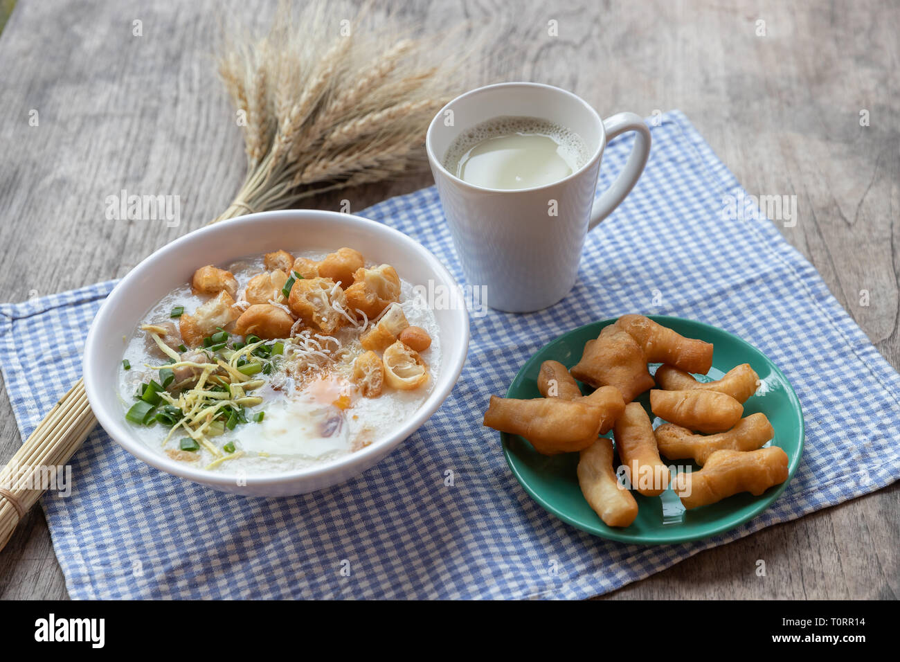 Breakfase pasto. Congee o riso porridge di carne macinata di maiale, uovo sodo con latte di soia e il cinese fritte doppio bastone di pasta Foto Stock