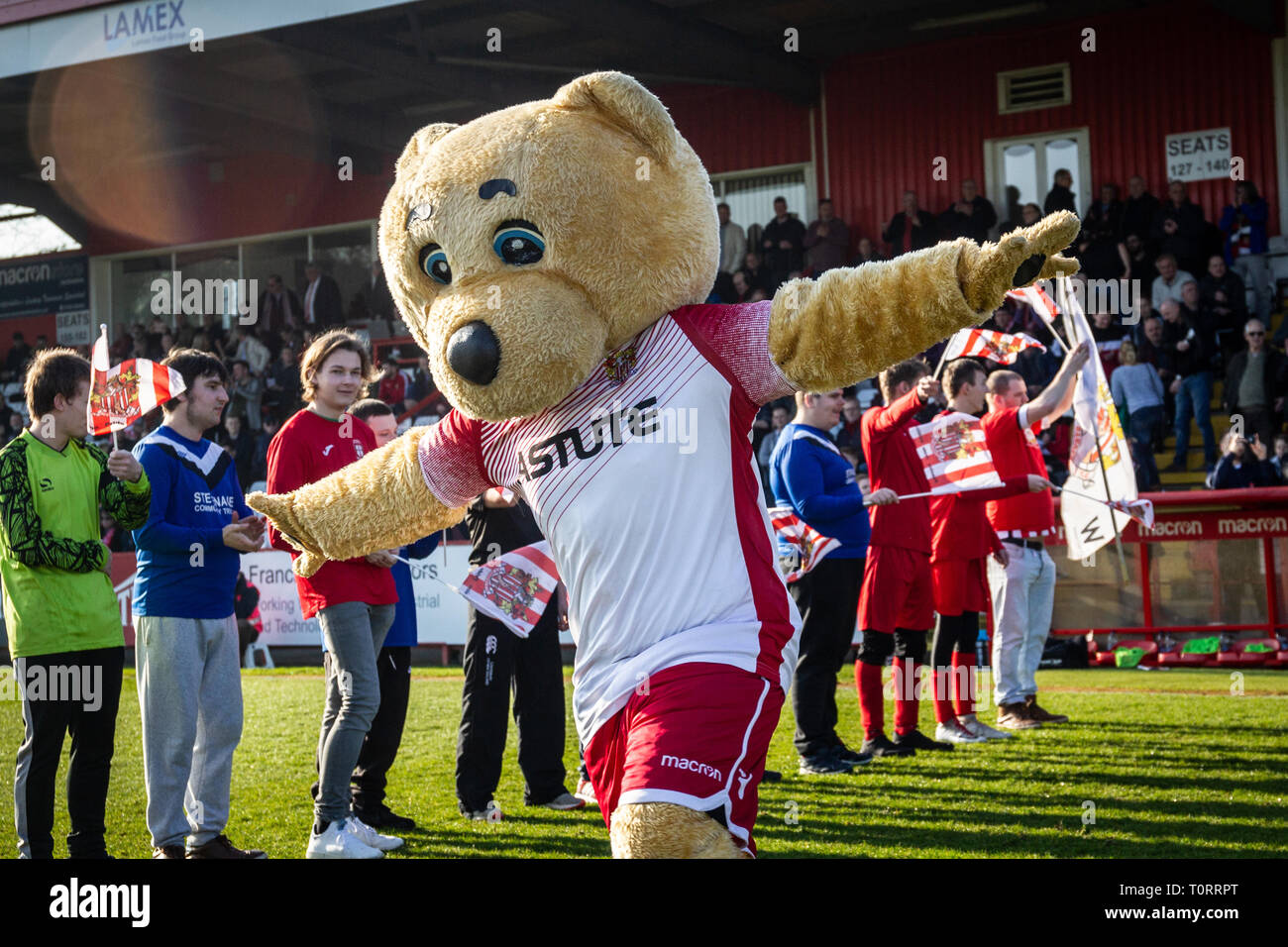 Football Club squadra mascotte in esecuzione sul passo prima dell inizio del gioco Foto Stock