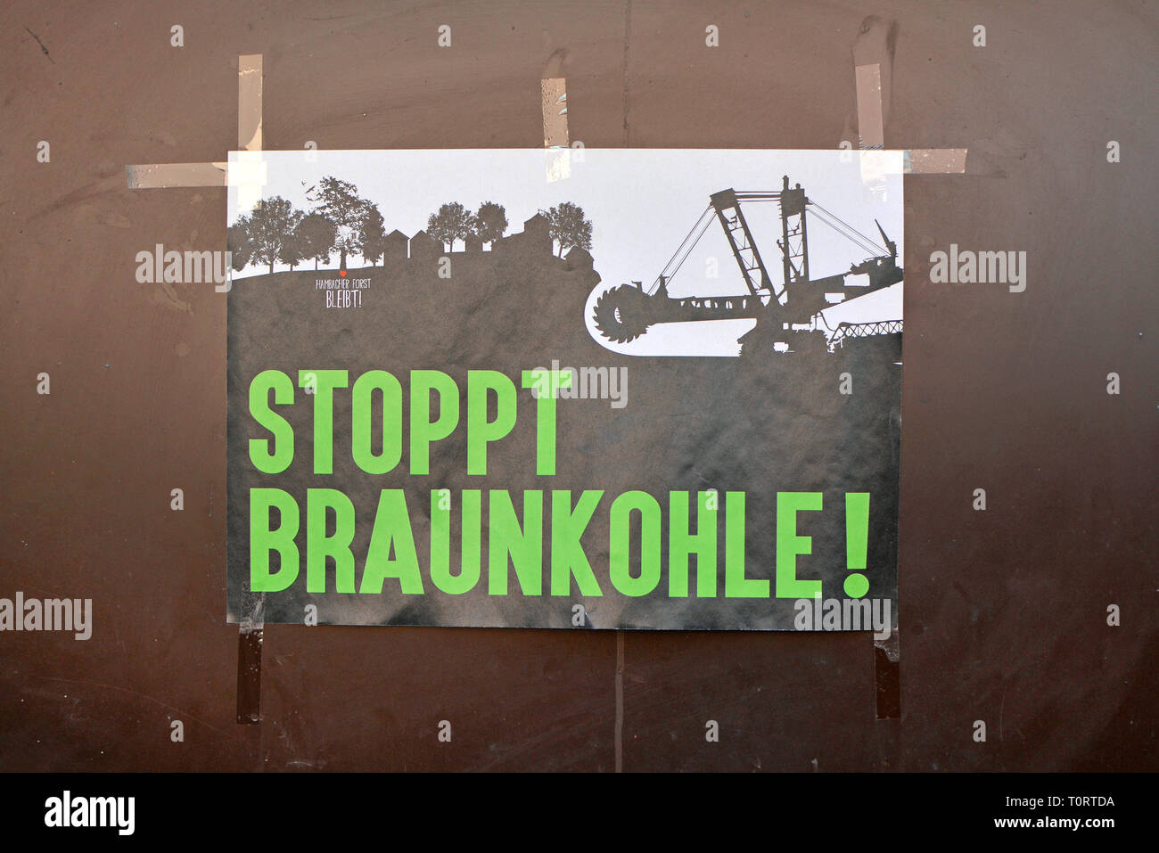 Poster di protesta messo sulla parete dicendo 'Stop carbone marrone' in grassetto lettere di colore verde e 'Hambacher foresta rimane' nell'angolo superiore in Germania Foto Stock
