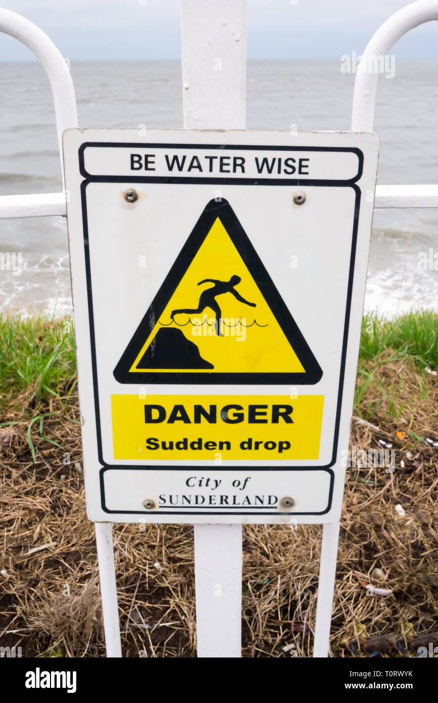 Un segnale di avvertimento per 'Sudden Drop' situato a Cliffe Park, Roker, Sunderland Foto Stock