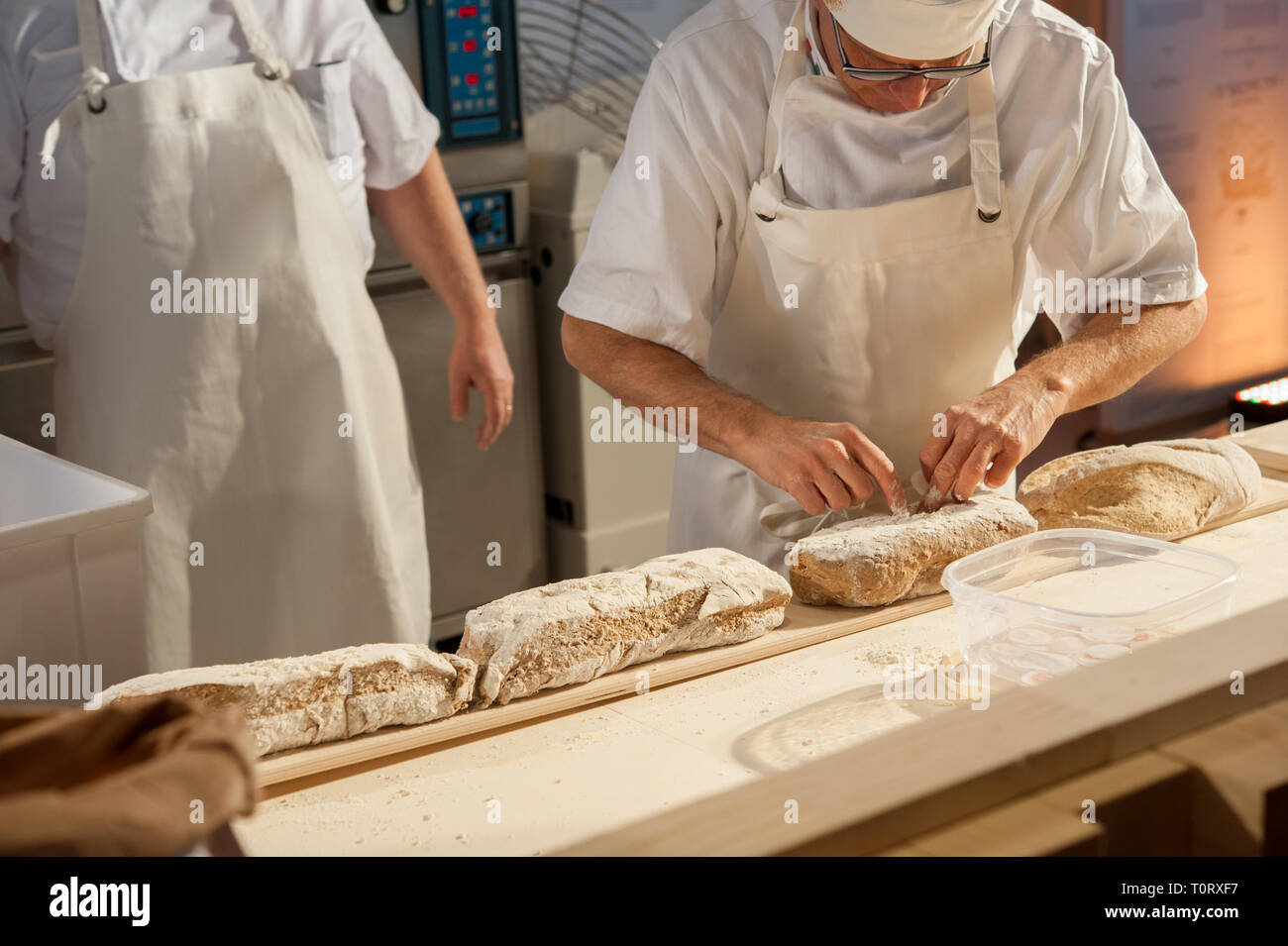 Il panettiere mettere focacce sulla buccia prima della cottura Foto Stock