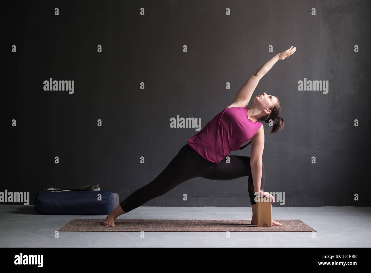 Donna facendo la Posizione laterale ad angolo di postura, Utthita Parsva Konasana. Foto Stock