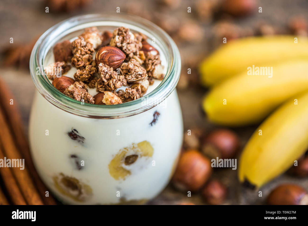 Servire di yogurt con muesli, banana e dadi Foto Stock