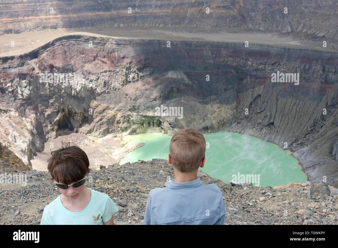 I bambini al di sopra dei Santa Ana vulcano in El Salvador guardando il turchese zolfo il cratere del lago Foto Stock