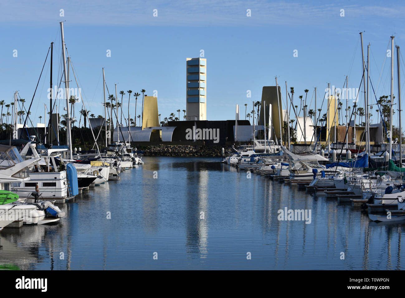 La facciata che nasconde un olio derrick a Grissom Isola di Long Beach harbor riflette nelle acque della marina. Foto Stock