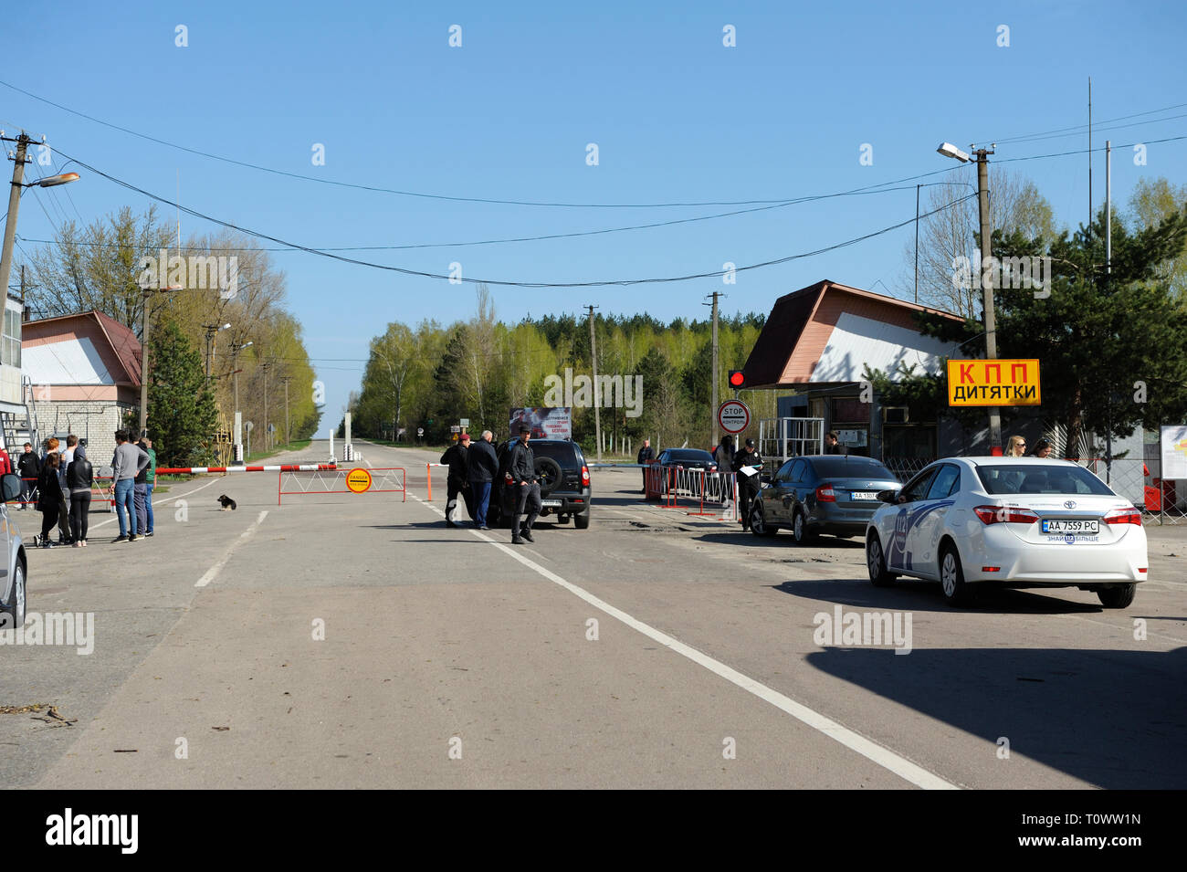 Segno di pericolo e a veicolo in marcia dalla barriera sul punto di attraversamento Dytiatky in cui Chernobyl Zona di esclusione inizia.Il 20 aprile 2018. Dytiatky, Ucraina Foto Stock