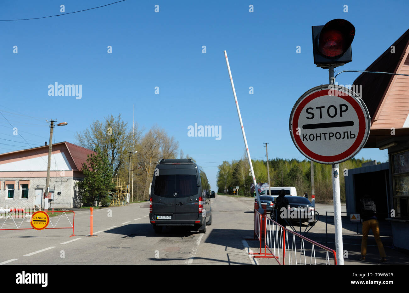 Stop e a veicolo in marcia dalla barriera sul punto di attraversamento Dytiatky su un modo di Chernobyl Zona di esclusione. Aprile 20,2018. Dytiatky, Ucraina Foto Stock