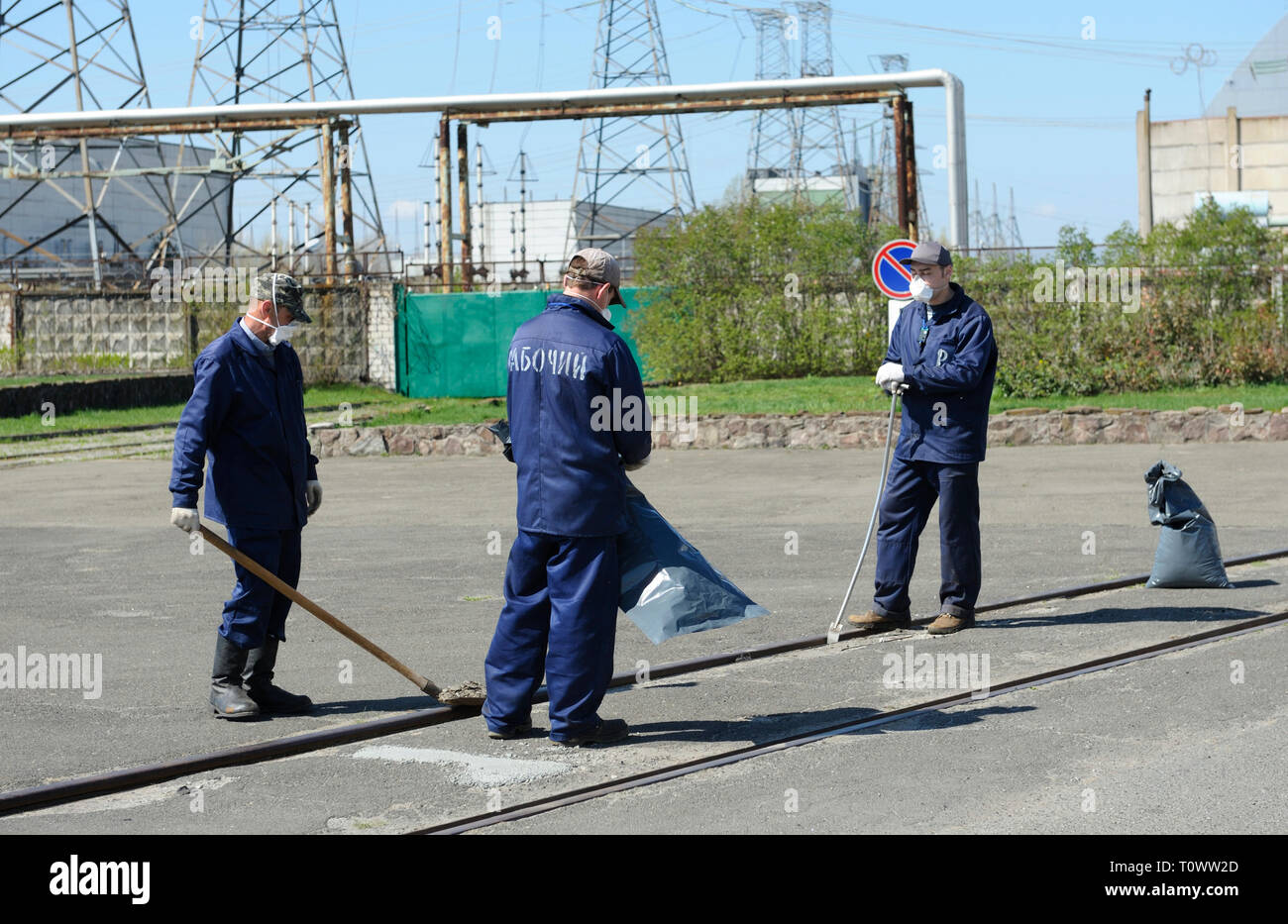 I lavoratori di indumenti protettivi decontaminare piazza vicino alla costruzione della centrale nucleare di Cernobyl. Aprile 20, 2018. Chernobyl, in Ucraina Foto Stock