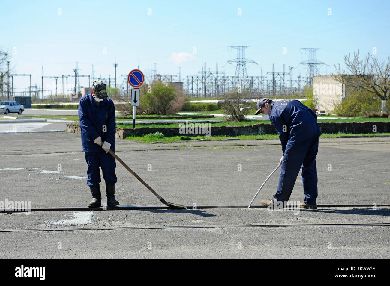 I lavoratori di indumenti protettivi decontaminare piazza vicino alla costruzione della centrale nucleare di Cernobyl. Aprile 20, 2018. Chernobyl, in Ucraina Foto Stock
