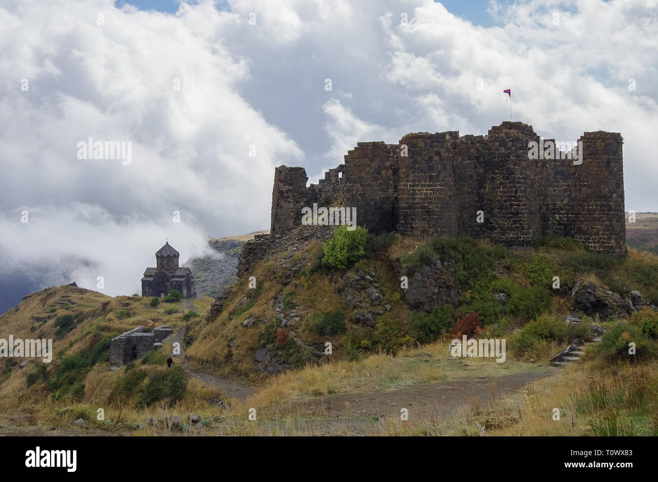 Fortezza di Amberd e San Astvatsatsin (Santa Madre di Dio) Chiesa in pendenza della montagna Aragats tra le nuvole. Armenia Foto Stock