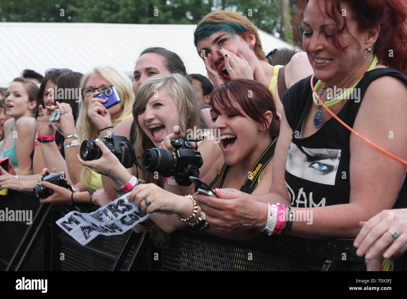 Felice fila anteriore ventole sono mostrati prima di iniziare un concerto all'aperto le prestazioni. Foto Stock