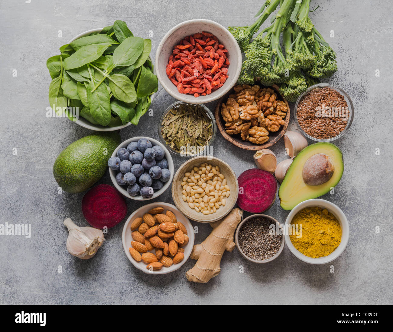 Pulire sano cibo - Ortaggi e legumi, frutta, superfoods su sfondo grigio. Mangiare sano concetto. Foto Stock