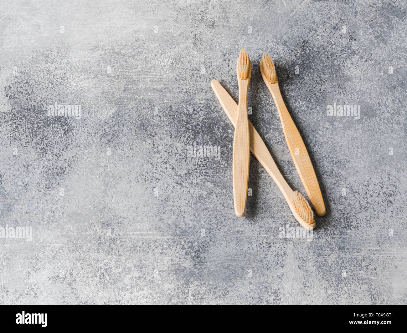 Tre gli spazzolini da denti di bambù su sfondo grigio. Uno stile di vita sostenibile rifiuti zero concetto. No oggetti in plastica. spazio copia Foto Stock