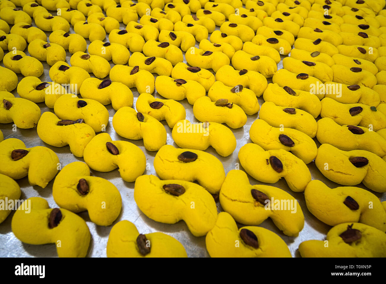 Eastern dolci da forno impostato in righe su un grande foglio di cottura. Giallo per la cottura con data nel mezzo. Il baklava turca sul vassoio da forno pronto per la vendita. Pastr Foto Stock