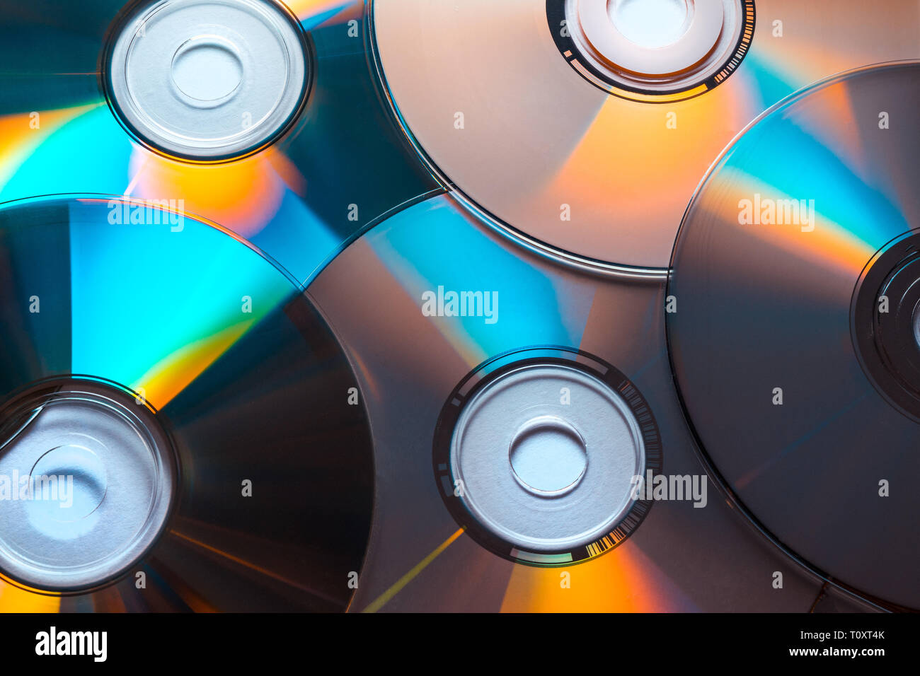 Close-up di una pila di dischi CD o DVD con riflessi colorati Foto Stock