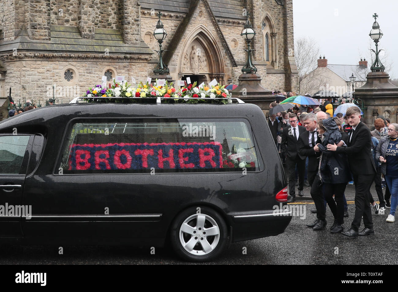 Madre Maria Barnard è trattenuto dal suo partner James Bradley come essi seguono il corteo funebre di St Patrick, Dungannon dopo il funerale del loro bambino, Morgan Barnard. Foto Stock