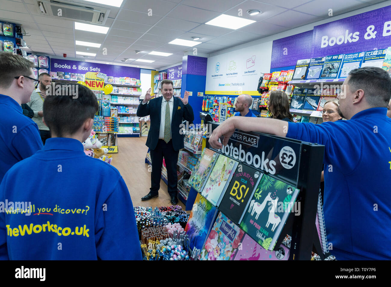 Un manager del negozio che dà un team motivazionale parlare alla riunione del team. Foto Stock