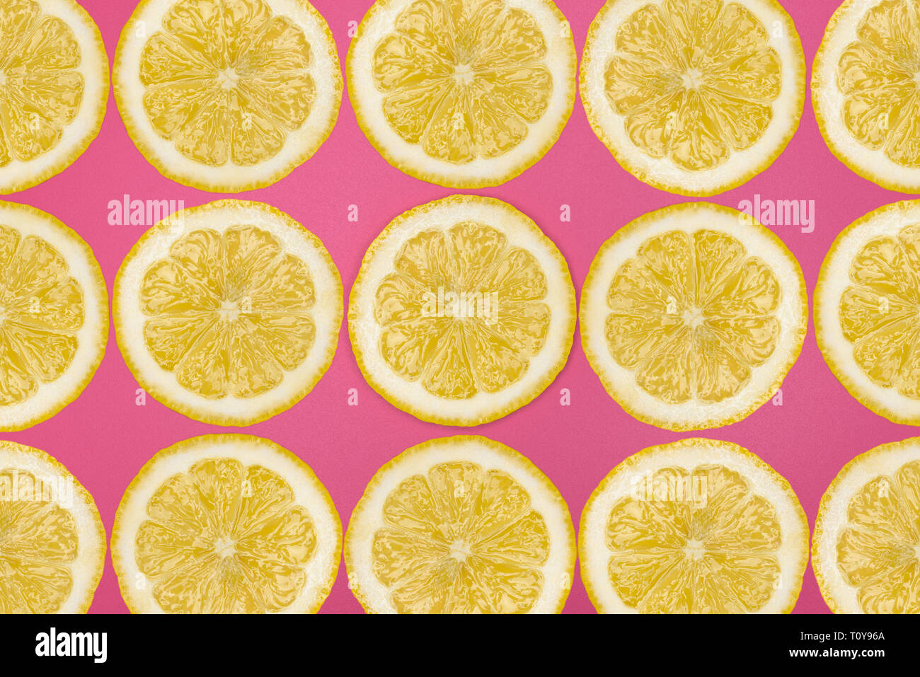 Modello realizzato da fettine di limone fresco su un sfondo rosa, vista aerea, flatlay. Sfondo di frutta. Foto Stock