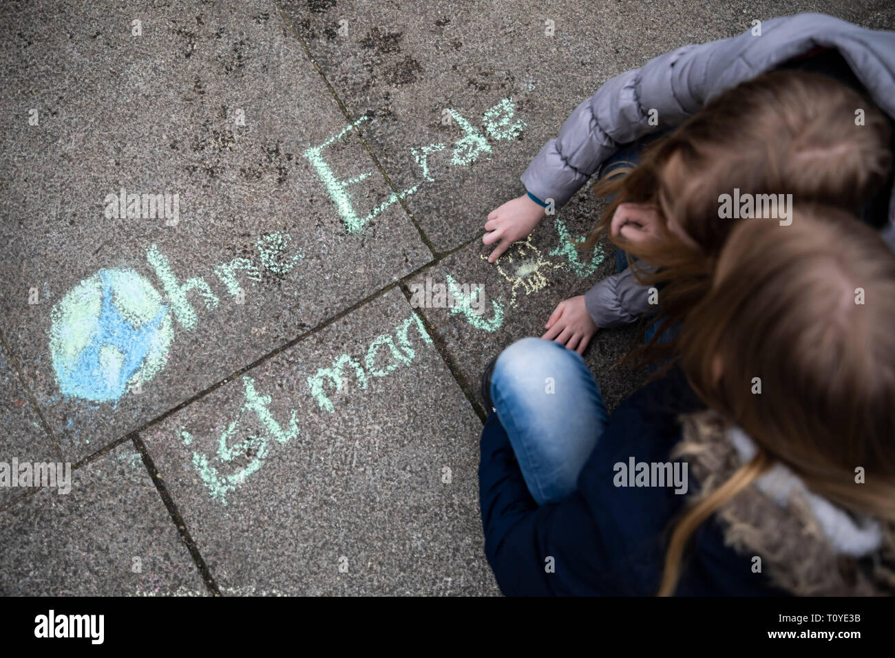 Berlino, Germania. 22 Mar, 2019. Due ragazze in clima rally "Venerdì per il futuro" all'Invalidenpark scrivere la frase "Senza terra vi sono morto" con un gessetto sul pavimento. Credito: Christoph Soeder/dpa/Alamy Live News Foto Stock