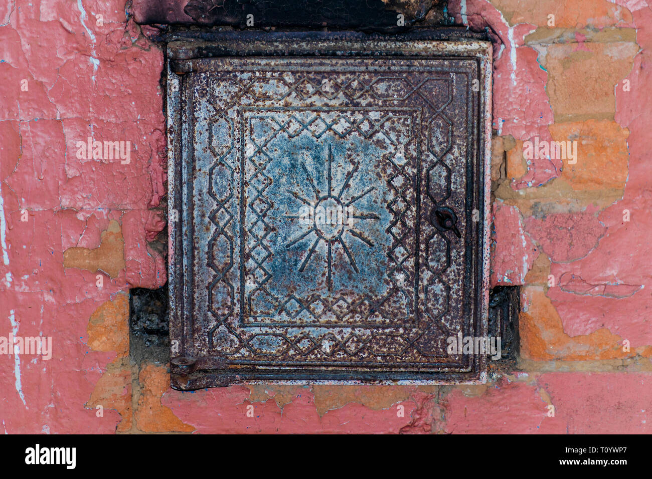 Ghisa porta con un disegno a rilievo in russo il forno a legna. Il forno è  fatto di mattoni rossi. Stufa riscaldamento della casa di villaggio.  Close-up Foto stock - Alamy