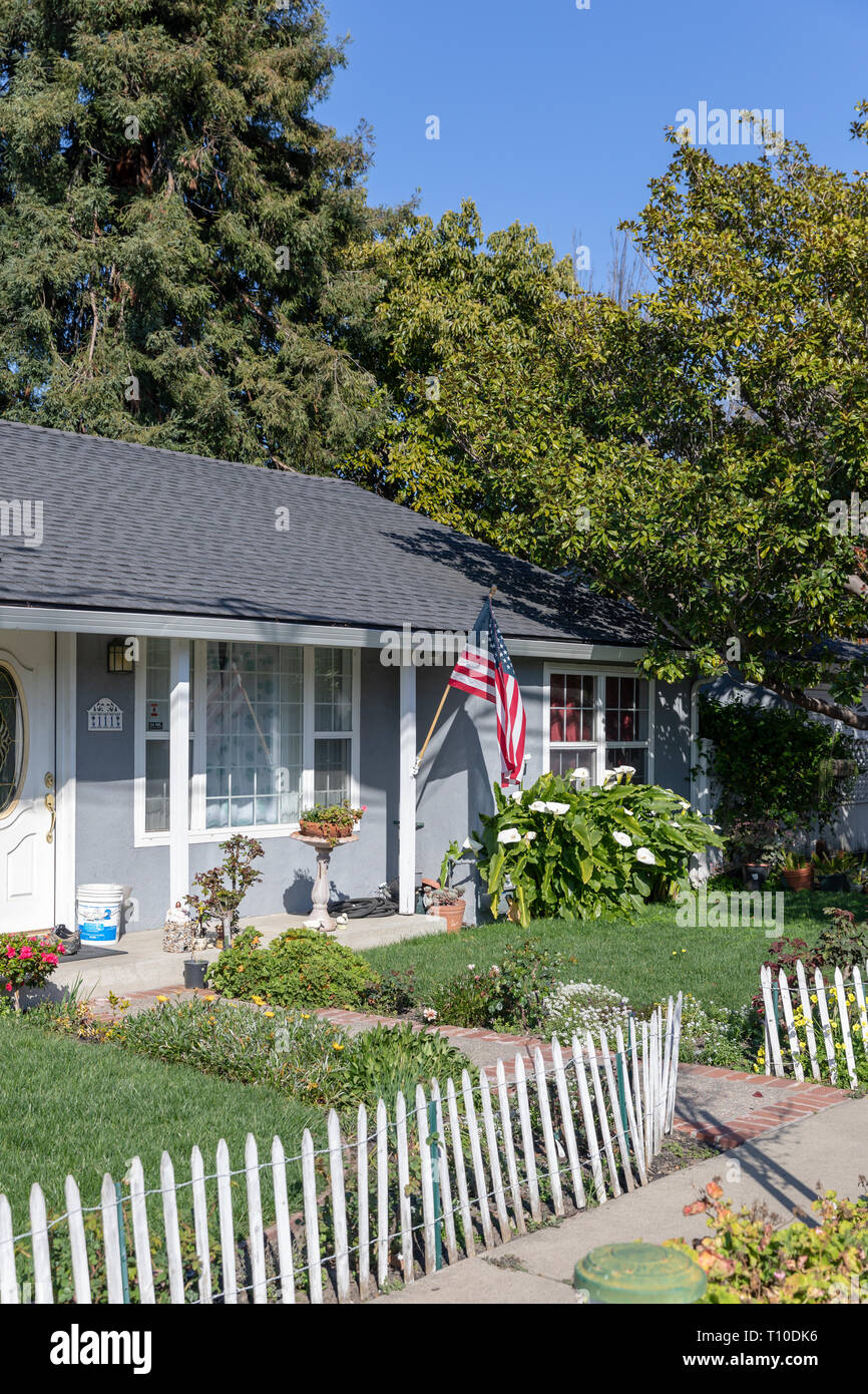 Casa americana con bandiera bianca e recinzione di legno; Sunnyvale, California, Stati Uniti d'America Foto Stock