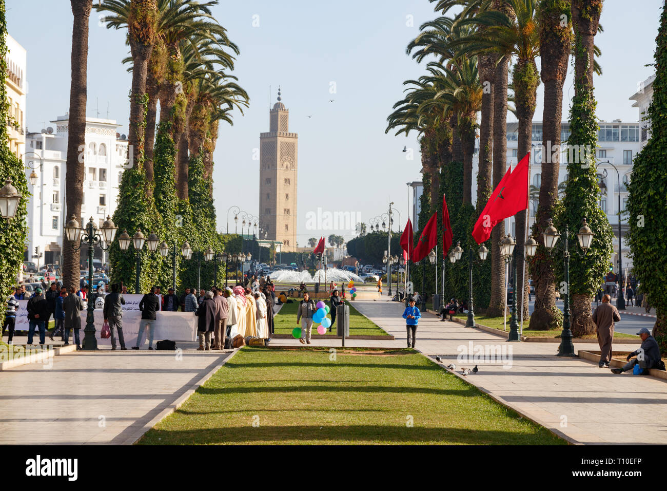 Vista del Avenue Mohammed V, con palme, persone non identificate e la moschea Assounna torre. Rabat il Marocco. Foto Stock