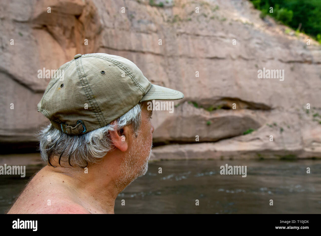 Uomo al rock. Ritratto di uomo alla roccia, sulla costa del fiume. L'uomo guarda la scogliera. Roccia sul fiume Gauja. Cliff è ripida roccia, e Foto Stock