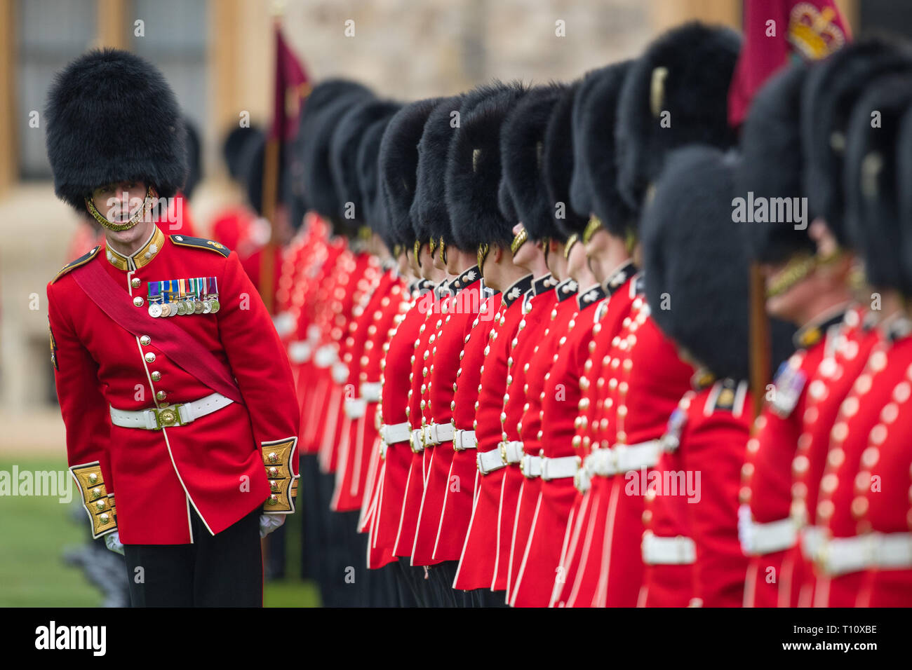 Truppe stand di attenzione a una medaglia cerimonia di presentazione e sfilata per le guardie di granatieri al Castello di Windsor, Berkshire. Foto Stock