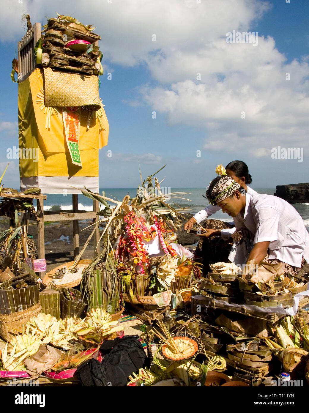 Un gruppo di persone Balinese si stanno preparando i sacrifici ai loro dèi prima della cerimonia. Ubicazione : Tanah Lot, Bali, Indonesia. Foto Stock