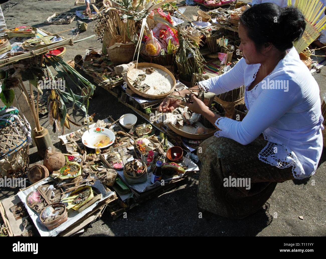 Una donna Balinese si stanno preparando l'offerta all'Induismo dèi prima della cerimonia. Ubicazione : Tanah Lot, Bali, Indonesia. Foto Stock