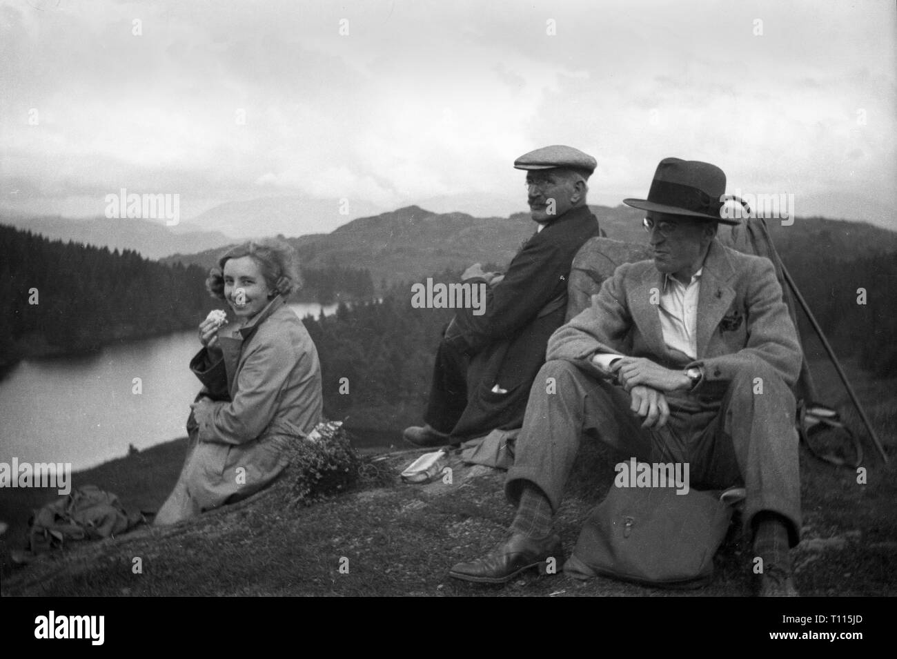 Famiglia di persone in appoggio con picnic sulla collina nel distretto del lago, Cumbria, la Gran Bretagna, Uk 1920s Foto Stock