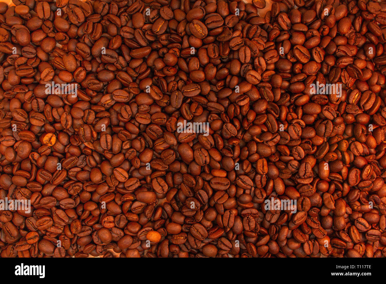 Chicchi di caffè tostati sfondo. Aroma caffeina bere ingrediente per bevanda al caffè. Close-up texture saturo. Foto Stock