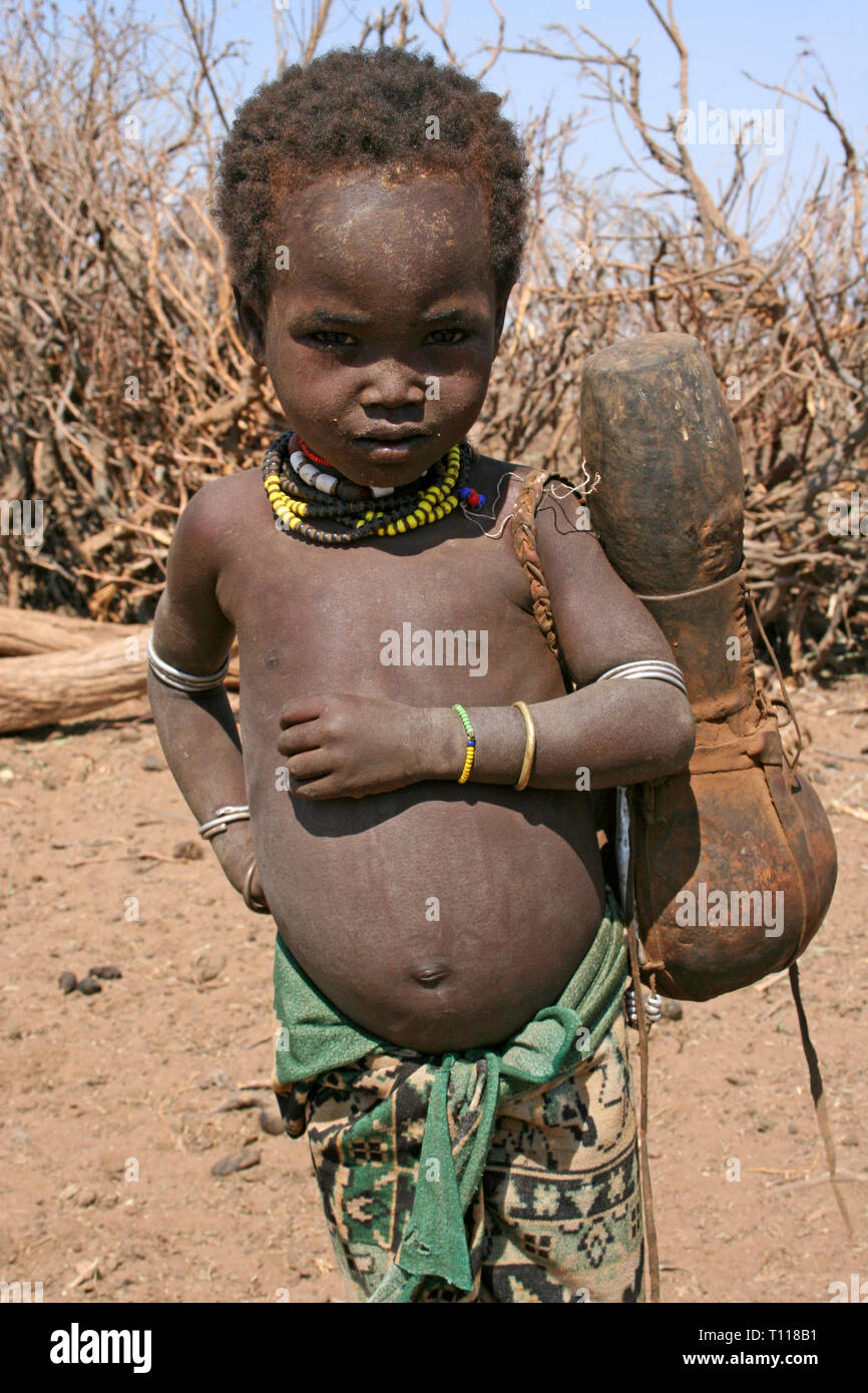 Arbore tribù Boy che trasportano il gourd, Valle dell'Omo, Etiopia Foto Stock