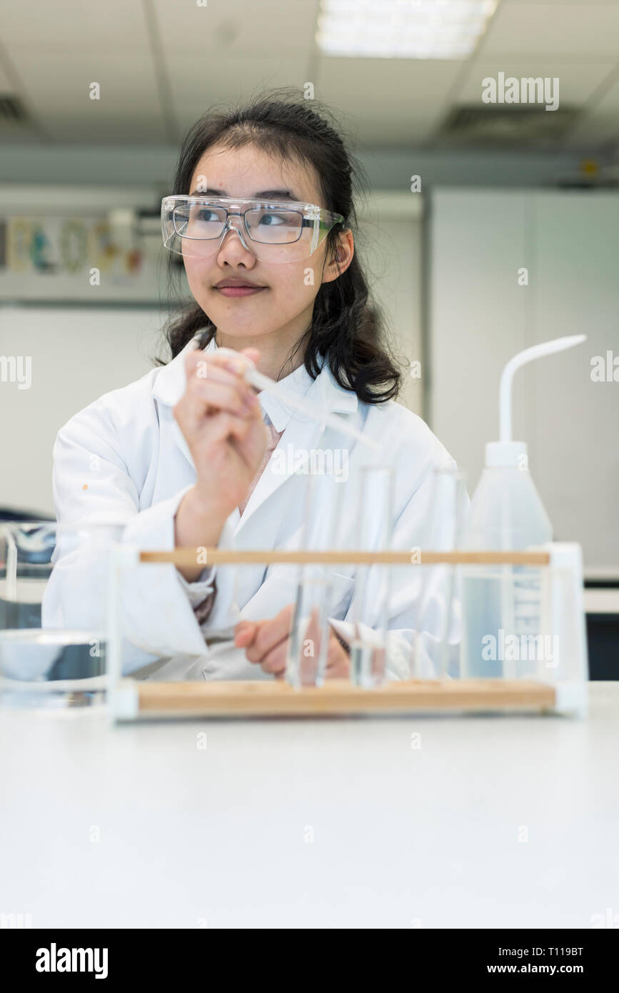 Una femmina internazionale studente asiatici nel laboratorio di scienze del suo college / scuola Foto Stock