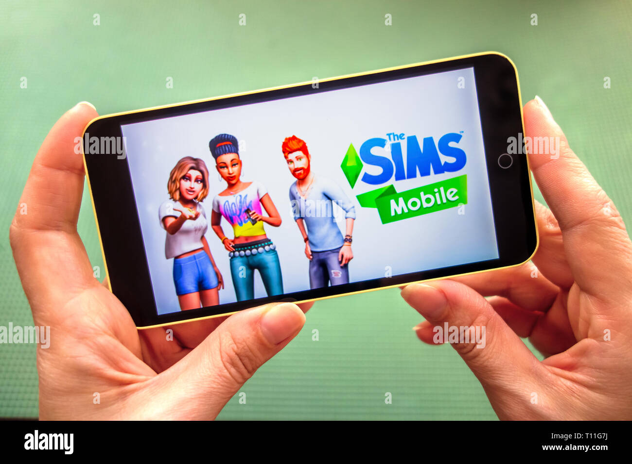 Berdyansk, Ucraina - 4 Marzo 2019 - Stretta di mano della persona che gioca The Sims gioco Mobile apllication. Foto Stock