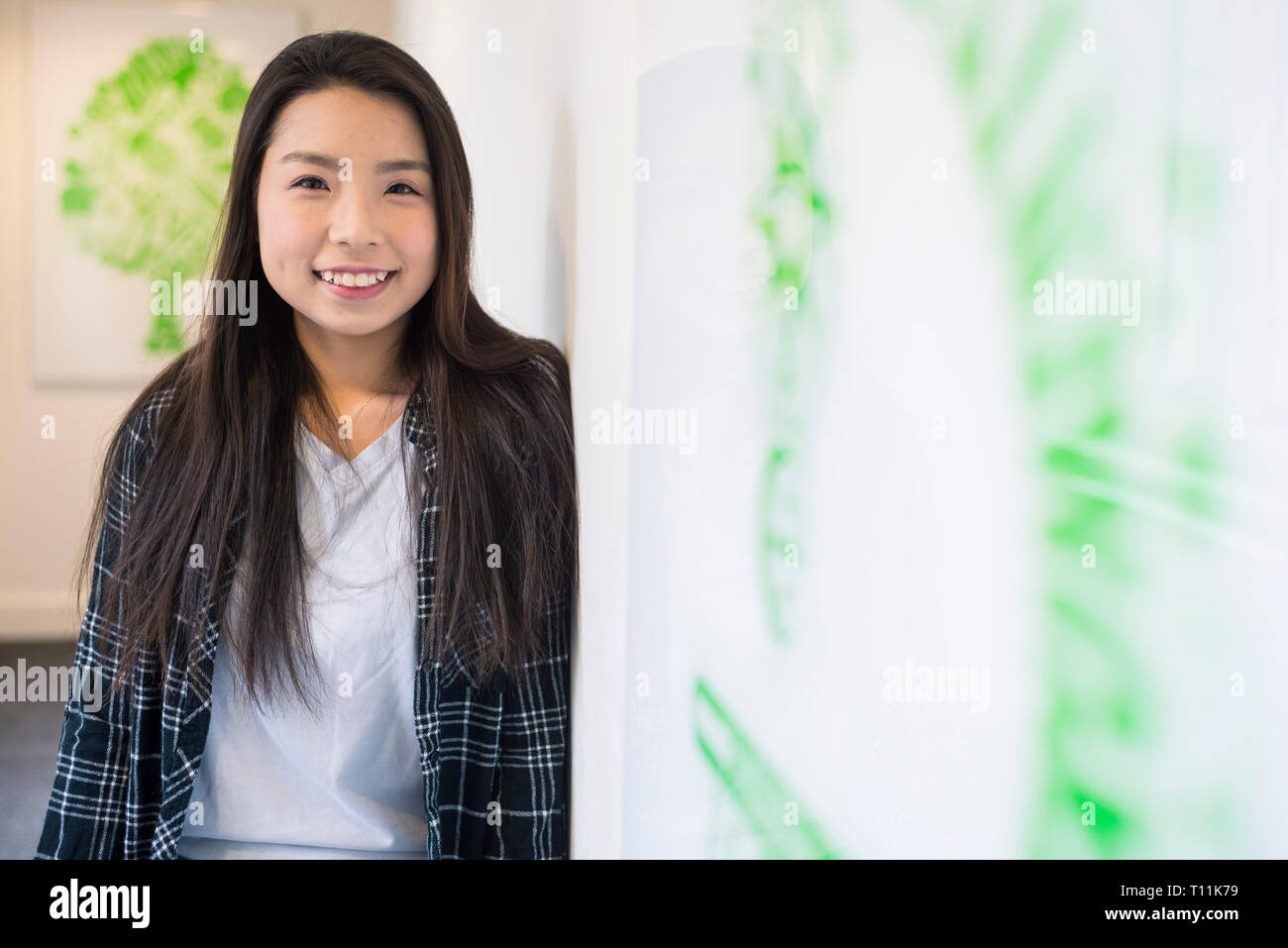 Un giovane del sud-est asiatico si erge la donna nel corridoio di un College di Cambridge. Foto Stock