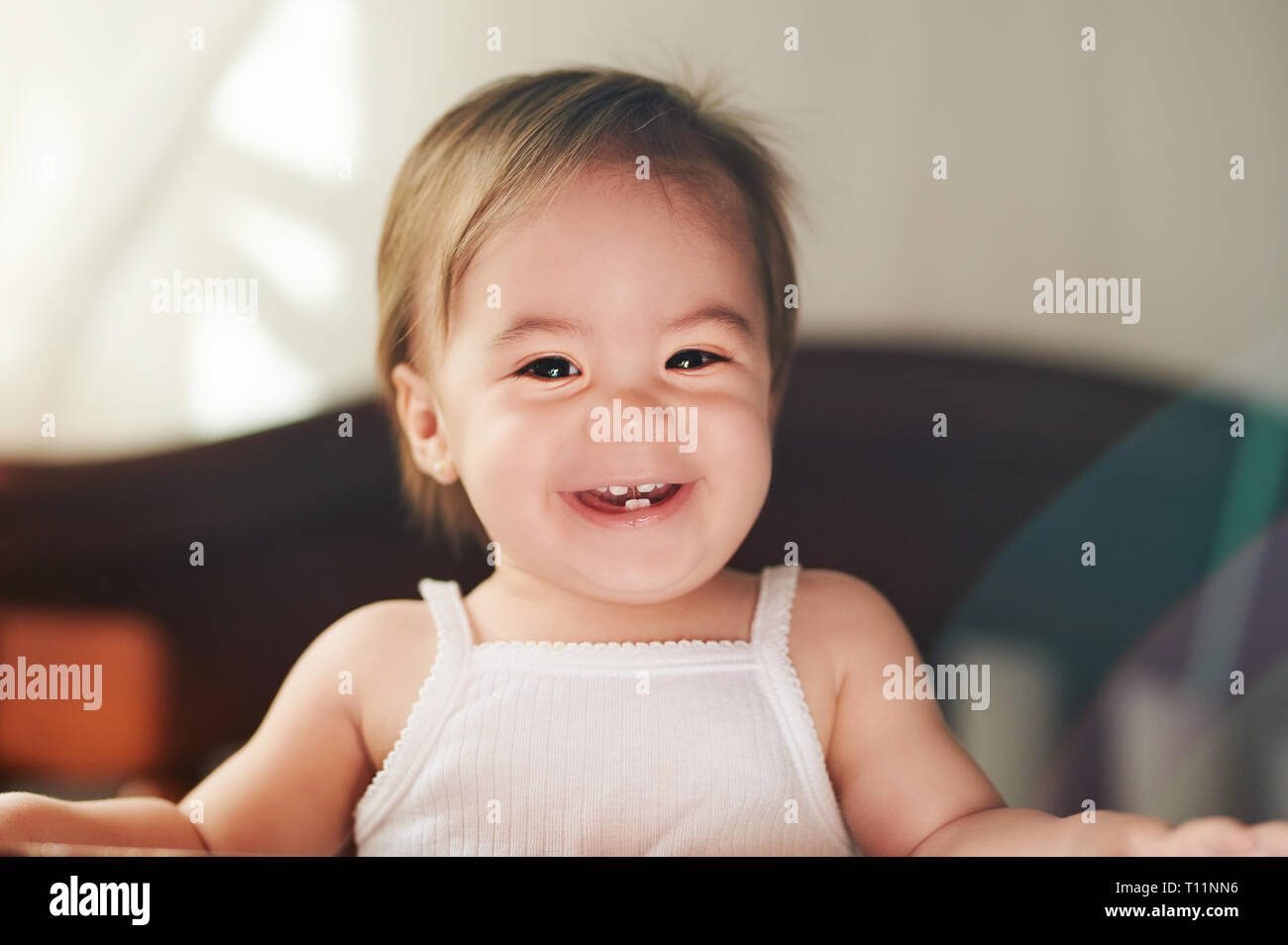 Sorridente bambina in t-shirt bianco cercando nella fotocamera Foto Stock