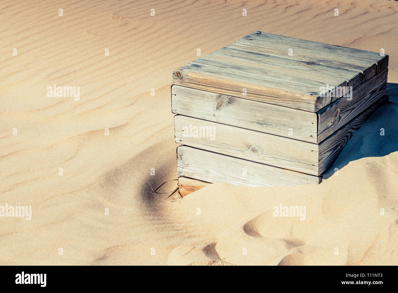 Un weathered scatola di legno consumato lentamente dalla sabbia in spiaggia di Bolonia, Spagna Foto Stock