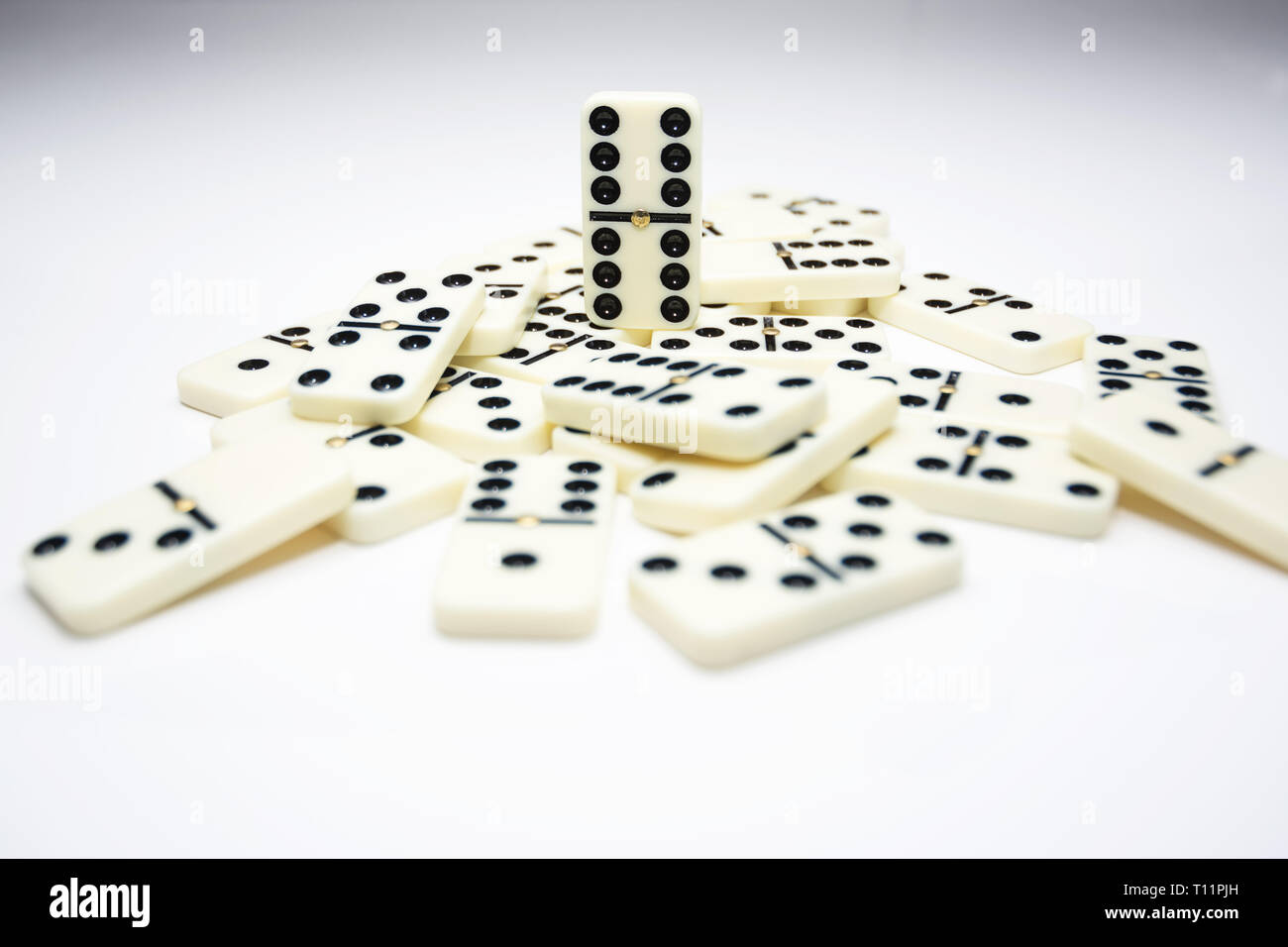 Concetto di leader con piastrelle di domino che rientrano nella pila e uno in piedi Foto Stock