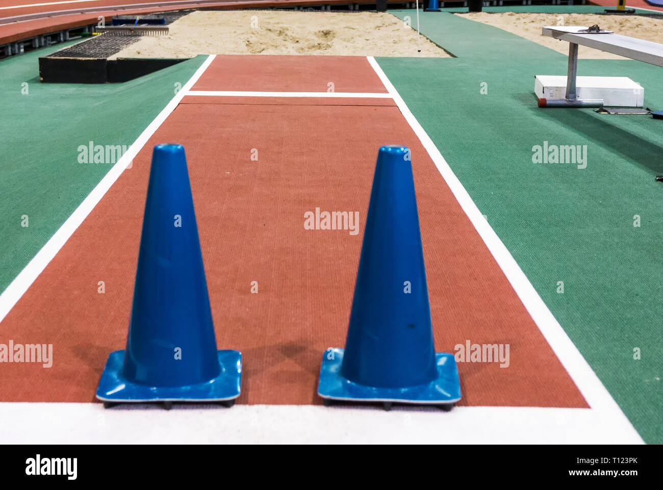 Due grandi coni blu sono impostati su una piscina lunga pista jumpr al blocco atleti provenienti da un salto nella sabbia. Foto Stock