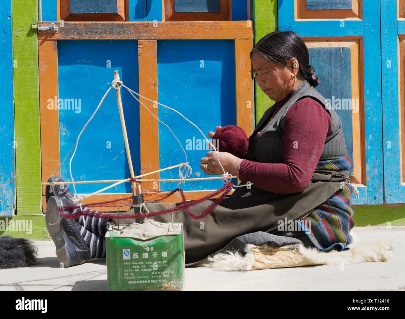 I vecchi Loba donna himalayana di filatura della lana di pecora, Lo Manthang, Mustang Superiore regione, Nepal. Foto Stock