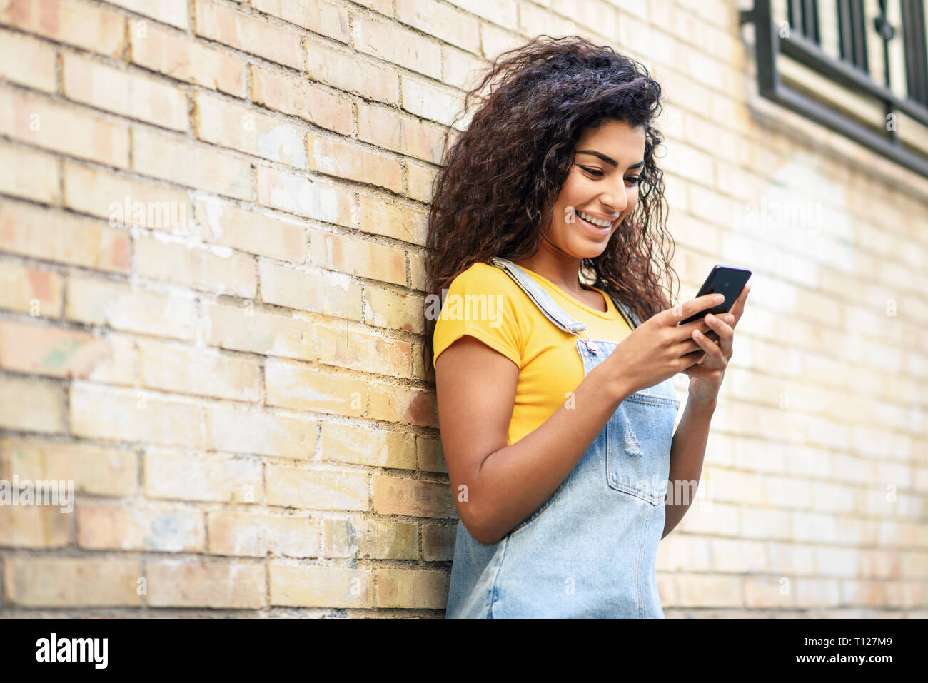 I giovani nord donna africana texting con il suo smart phone all'aperto Foto Stock